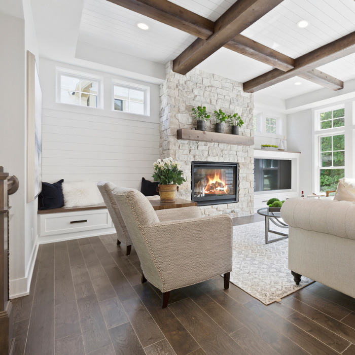 Open Living Room with beige sofas and fireplace with wood floors