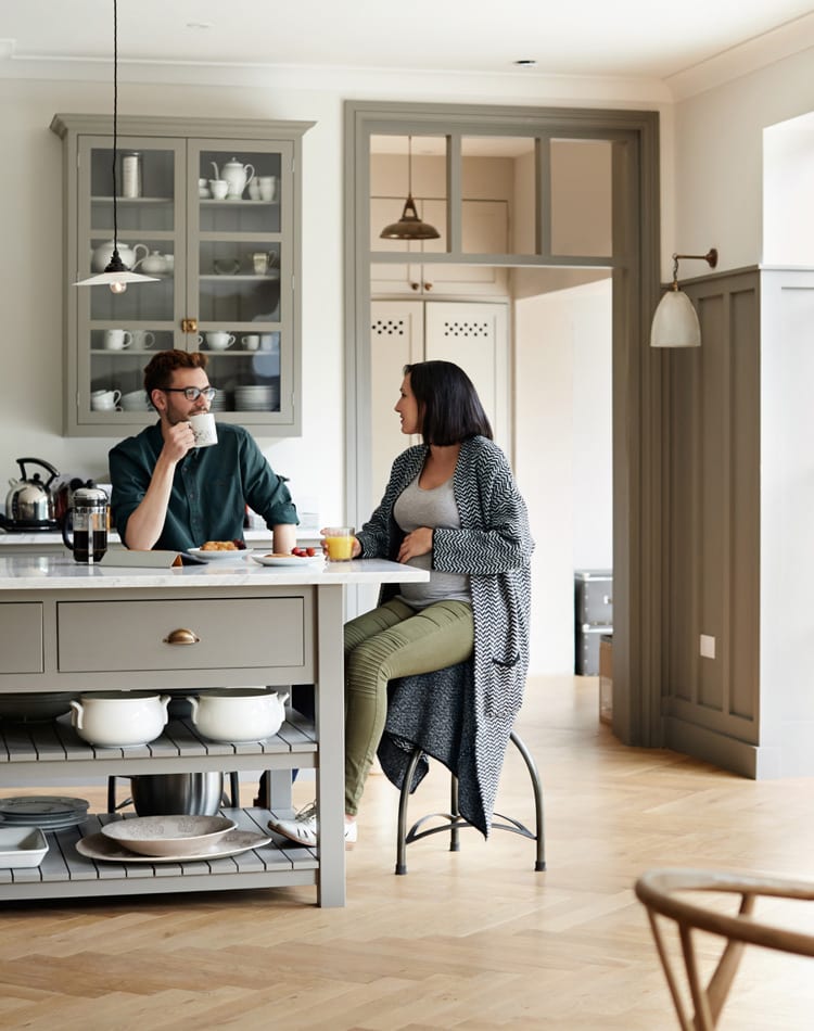 Man and woman sitting at kitchen island enjoying breakfast together