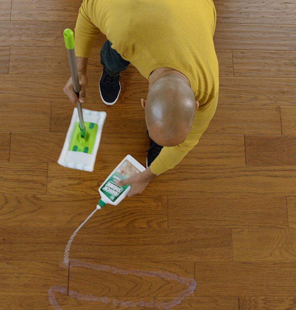 Man squirting Quick Shine® Floor Finish into s-pattern on wood floor