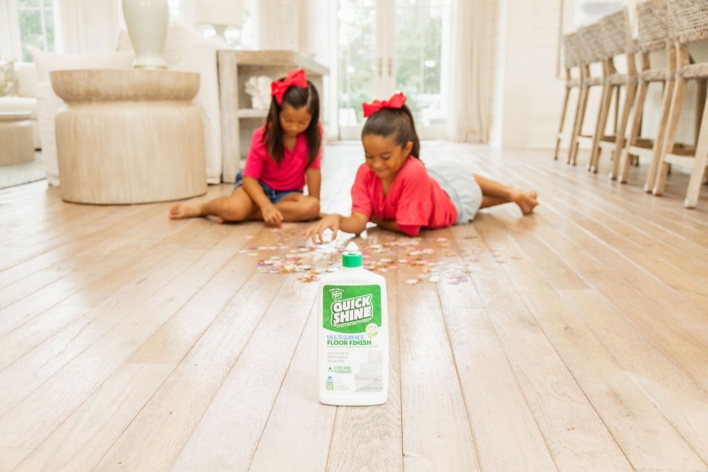 little girls on floor with puzzle and quick shine floor finish in foreground