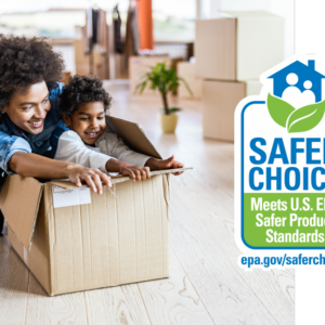 Woman squatting down behind child sitting in brown shipping box in a room in their new home